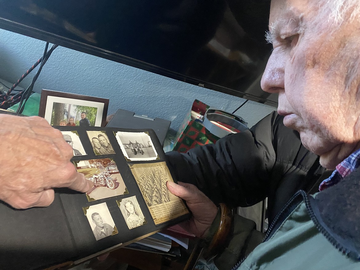 Lee Gibson's father flips through one of many photo albums that showcase the Gibson family's long line of motorcycle lovers. (MADISON HARDY/Press)