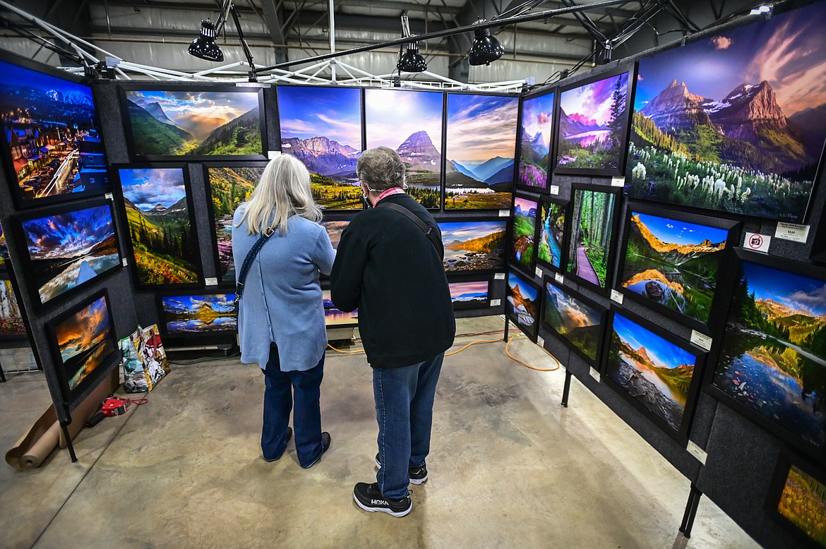 Shoppers browse at Eric Reese's Fine Art Photography stand at the Artists and Craftsmen of the Flathead's 40th annual Christmas show at the Flathead County Fairgrounds on Friday, Nov. 26. (Casey Kreider/Daily Inter Lake)