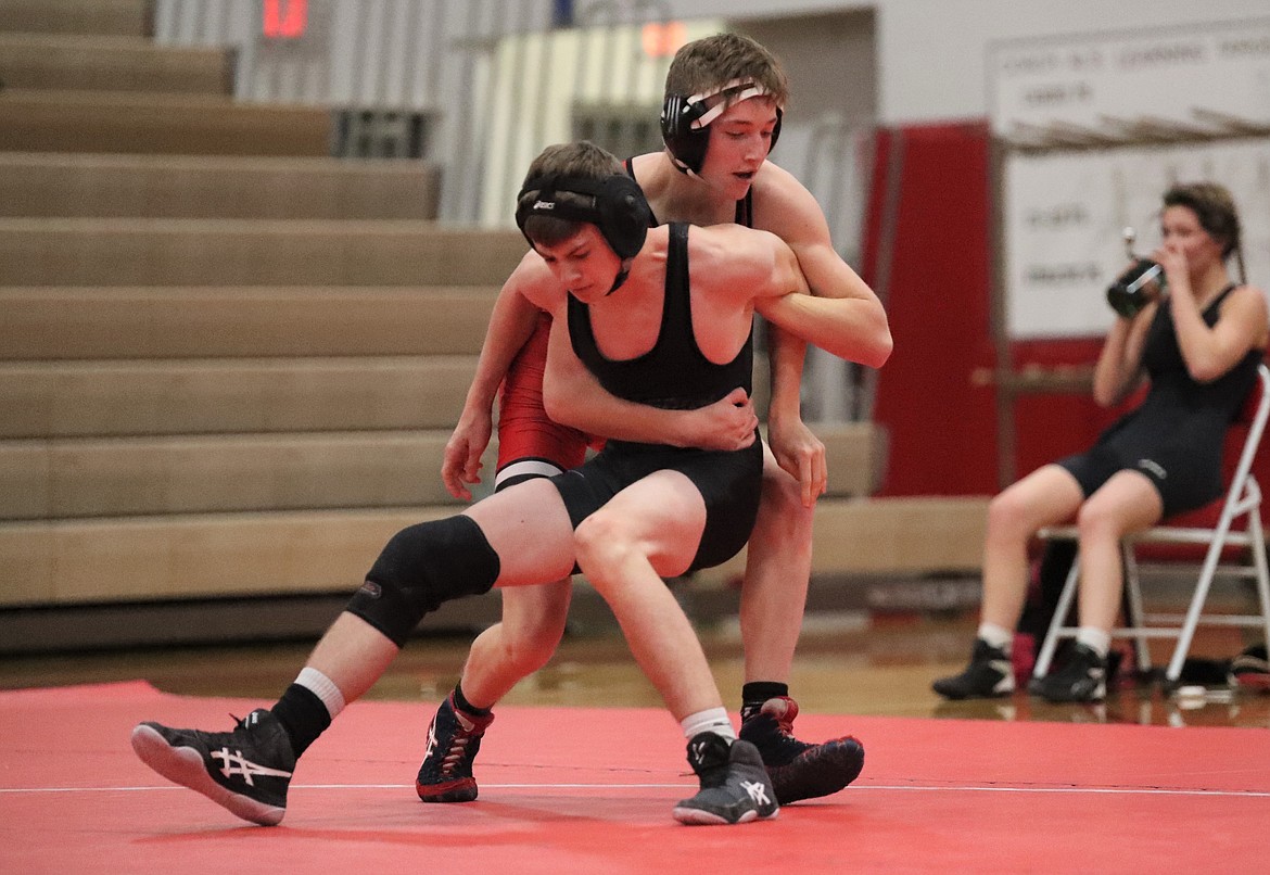 Justin Lewis (in red) tries to earn a takedown during his match with Parker Warren on Wednesday.
