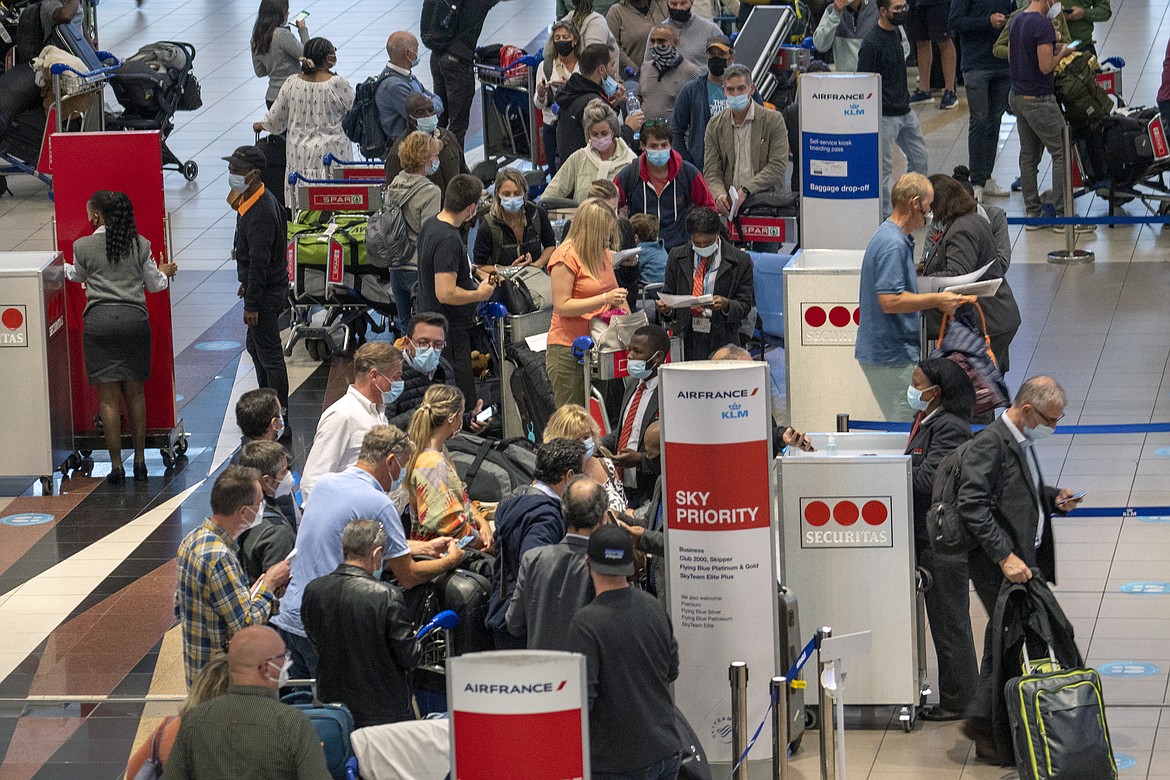 People line up to get on the Air France flight to Paris at OR Tambo International Airport in Johannesburg, South Africa, Friday Nov. 26, 2021. A slew of nations moved to stop air travel from southern Africa on Friday in reaction to news of a new, potentially more transmissible COVID-19 variant that has been detected in South Africa. Scientists say it is a concern because of its high number of mutations and rapid spread among young people in Gauteng, the country's most populous province. (AP Photo/Jerome Delay)