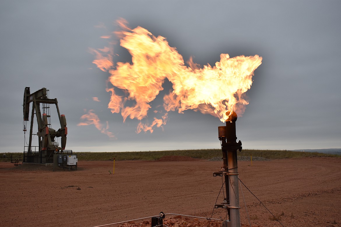 A flare burns natural gas at an oil well Aug. 26, 2021, in Watford City, N.D. (AP Photo/Matthew Brown, File)