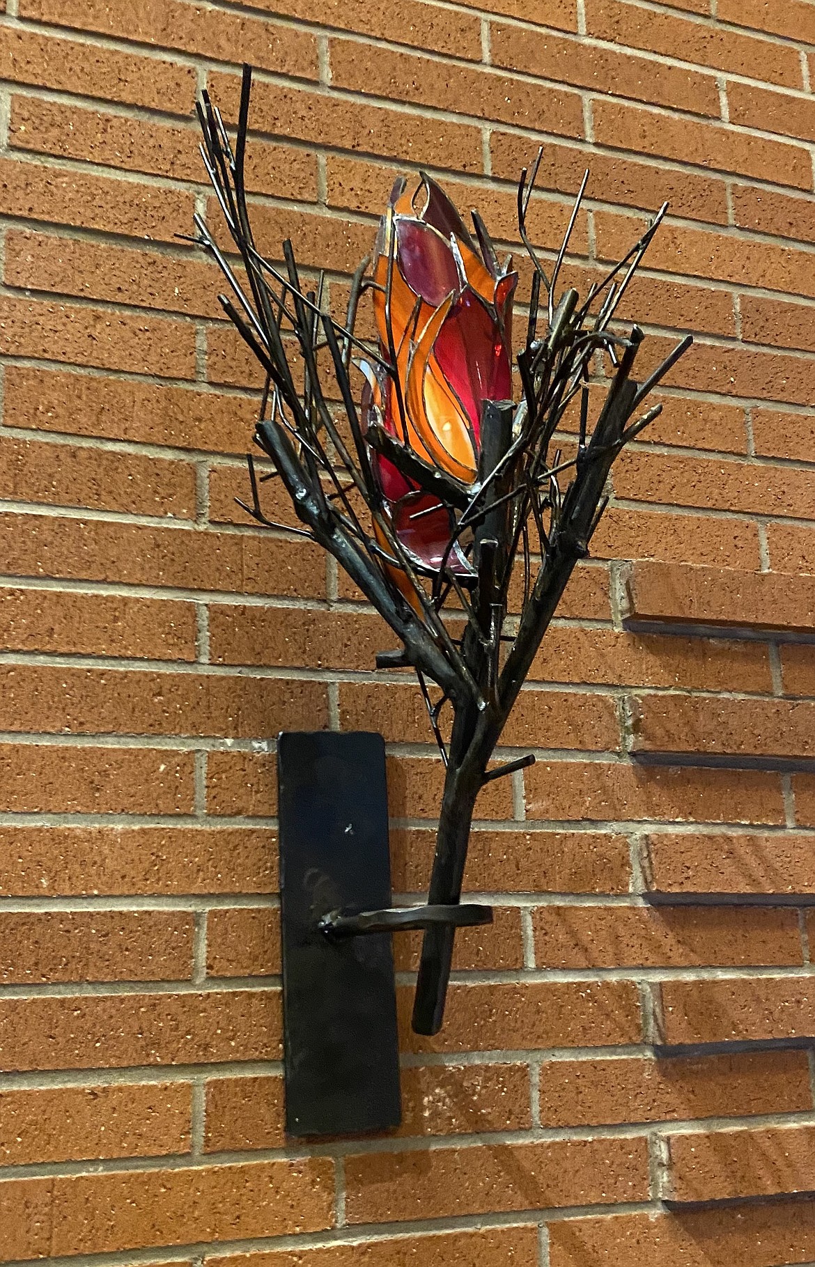 A collaborative art-piece by Tyree Riggs, who did the metal-work, and her sister-in-law Shannon Erwin who crafted the stained glass flames for this lamp that hangs in the sanctuary of Trinity Lutheran Church in Coeur d'Alene.