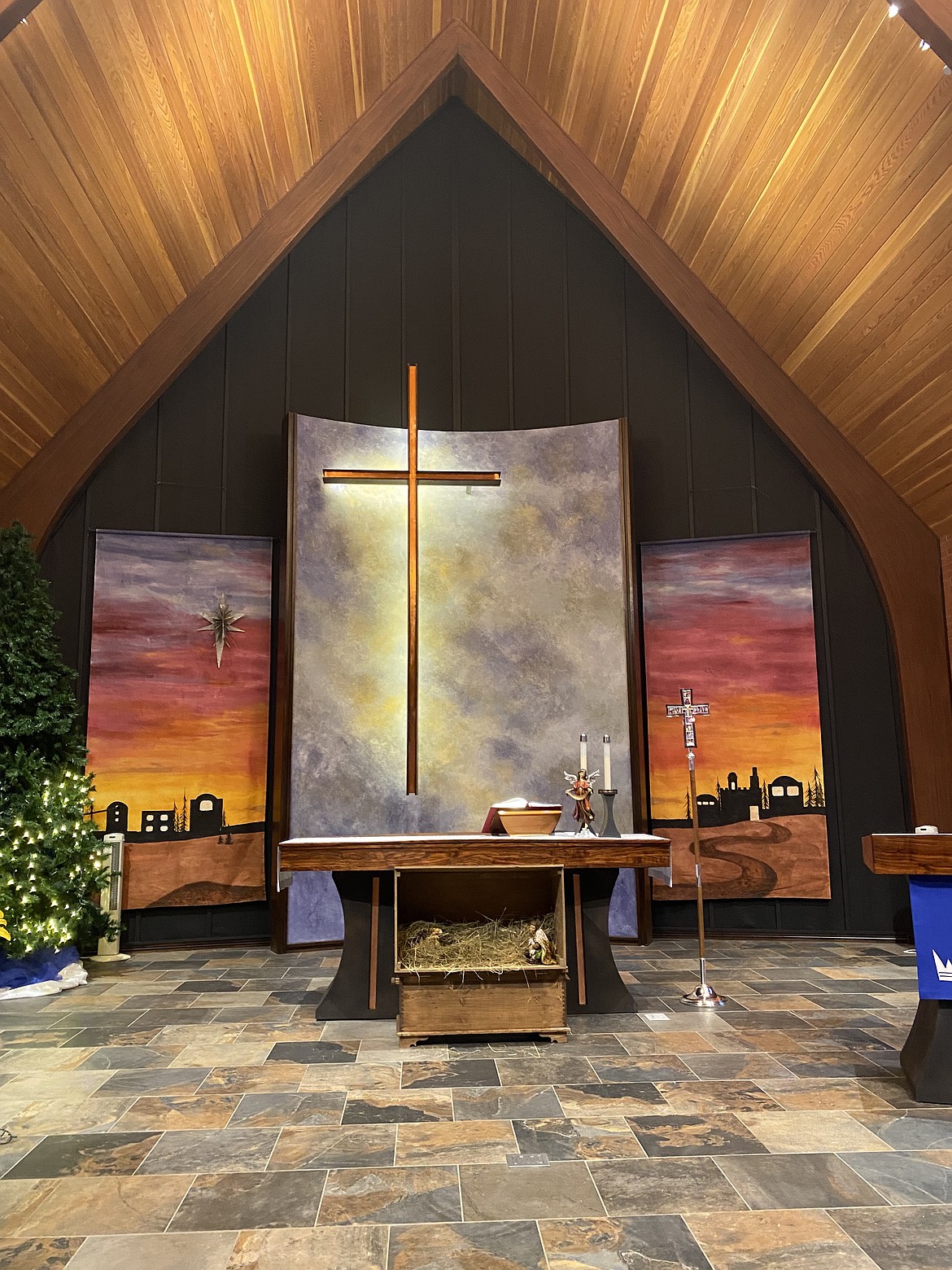 The two large, hand-painted panels created by local artist Shannon Erwin on either side of the cross, are installed each Christmas season to mark the beginning of Advent.