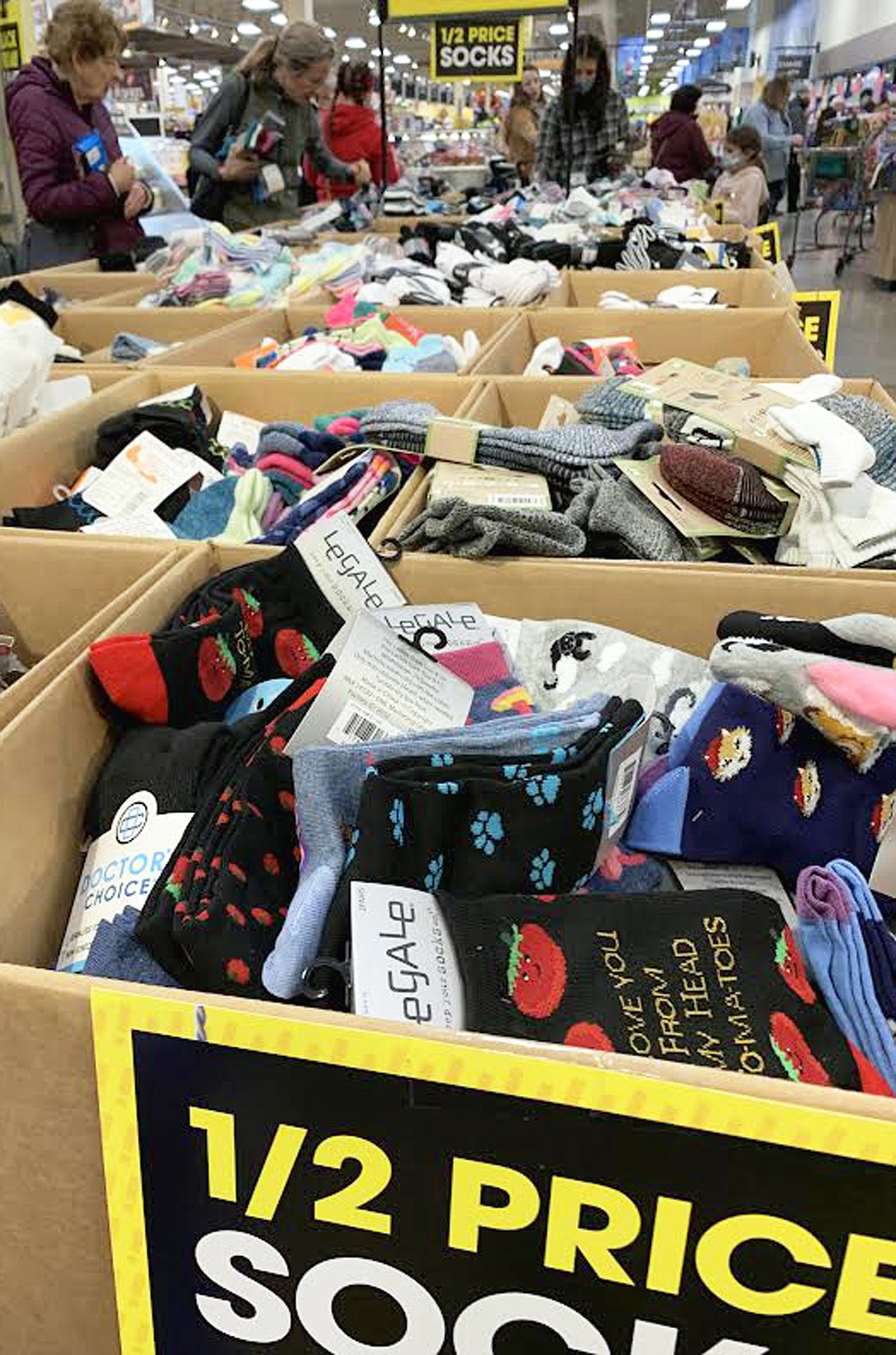 Shoppers peruse the socks on sale for half price at Fred Meyer on Friday.