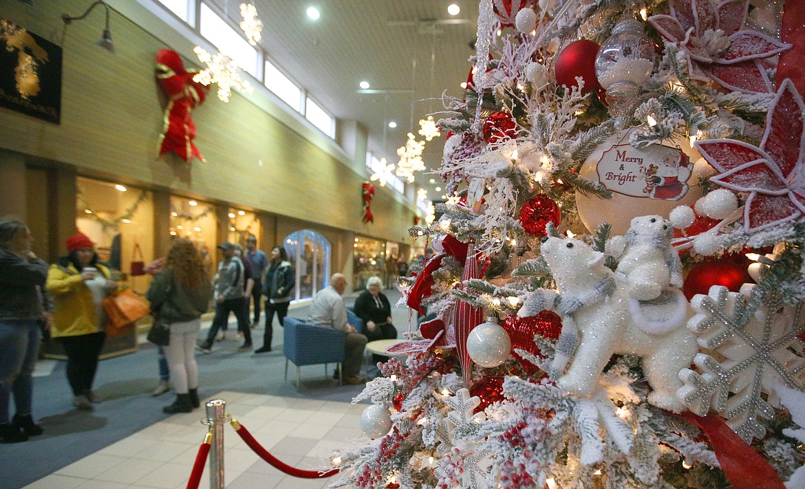 Ornaments hang from a Christmas tree in The Coeur d'Alene Resort Plaza Shops as shoppers mingle on Friday