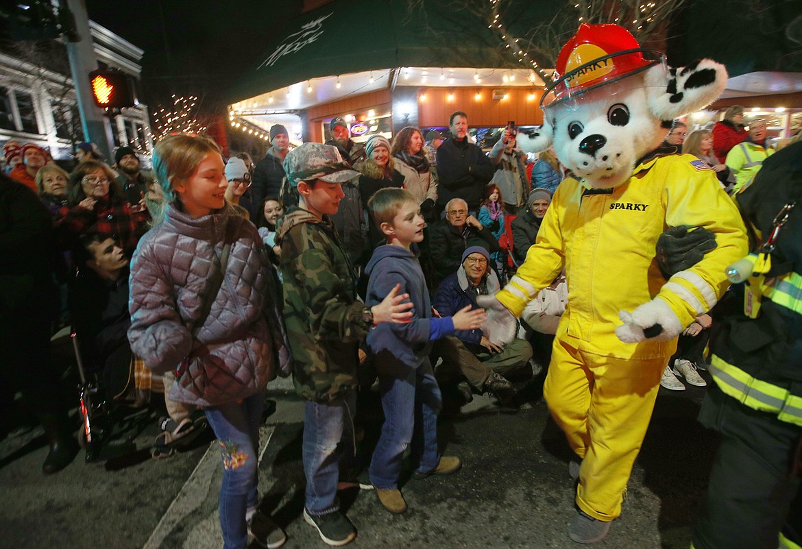 Sparky the Fire Dog greets kids during the 29th annual Lighting Ceremony Parade Friday night on Sherman Avenue.