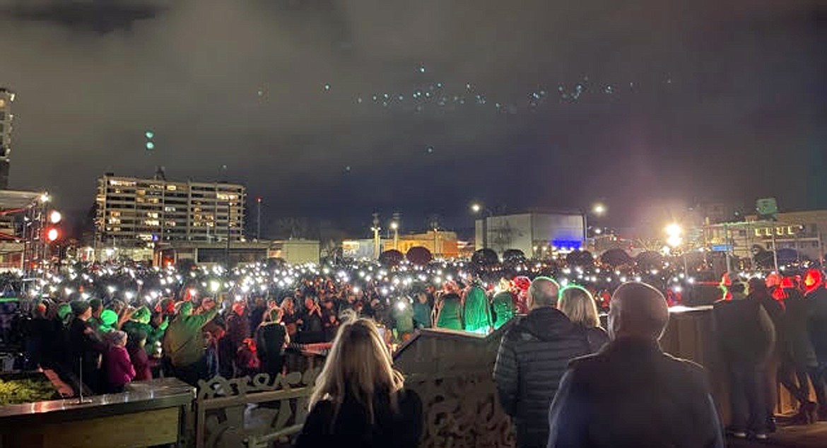 Photo by Clint Schroeder 
People hold up their phone flashlights during The Coeur d'Alene Resort's lighting ceremony Friday.