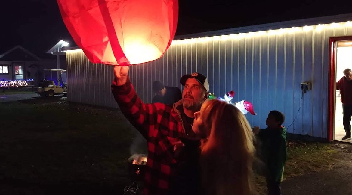 Plains resident Nick Ferrara releases a lantern during the annual Cancer Network of Sanders County lantern launch fundraiser Saturday night at the Sanders County Fairgrounds. Nick's wife Kathi also released a lantern during the fundraiser, which is part of a year-long series of events to raise funds for the Network and its support of cancer patients who are undergoing cancer treatment. (Chuck Bandel/Valley Press)