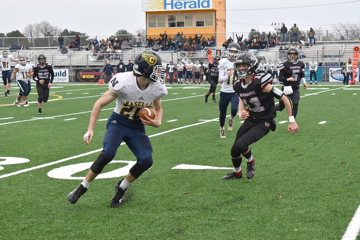 Almira/Coulee-Hartline High School junior Cody Allsbrook (11) goes after a rushing Naselle High School player during the state semifinal game Saturday.