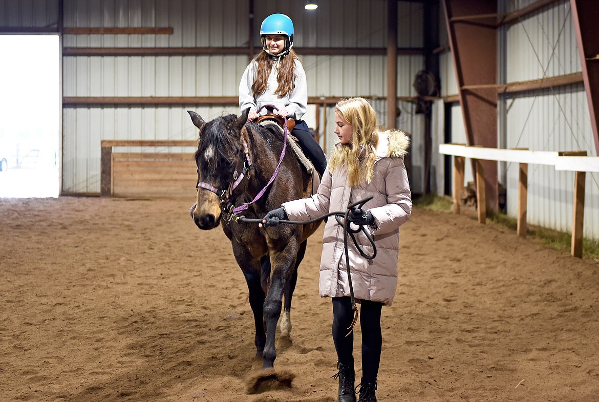 Whitefish Christian Academy sixth grade student Jessica Sukkarie rides while her classmate Annabelle Barrile leads the horse as part of the school's horsemanship class on Friday, Nov. 12 at Lost Creek Ranch. (Whitney England/Whitefish Pilot)