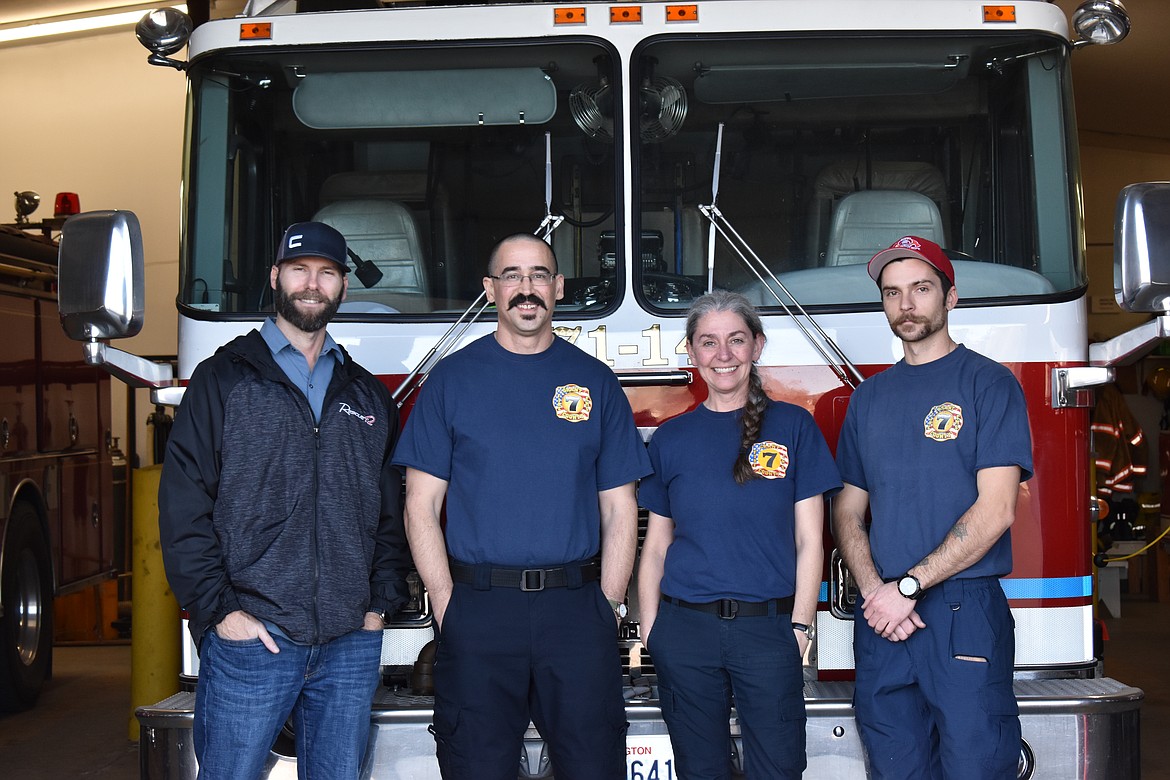 From left to right, Adam Sitton, Joshua Chambers, Jane Chambers and Viktor Bragar stand in front of a fire truck at the Grant County Fire District 7 station.