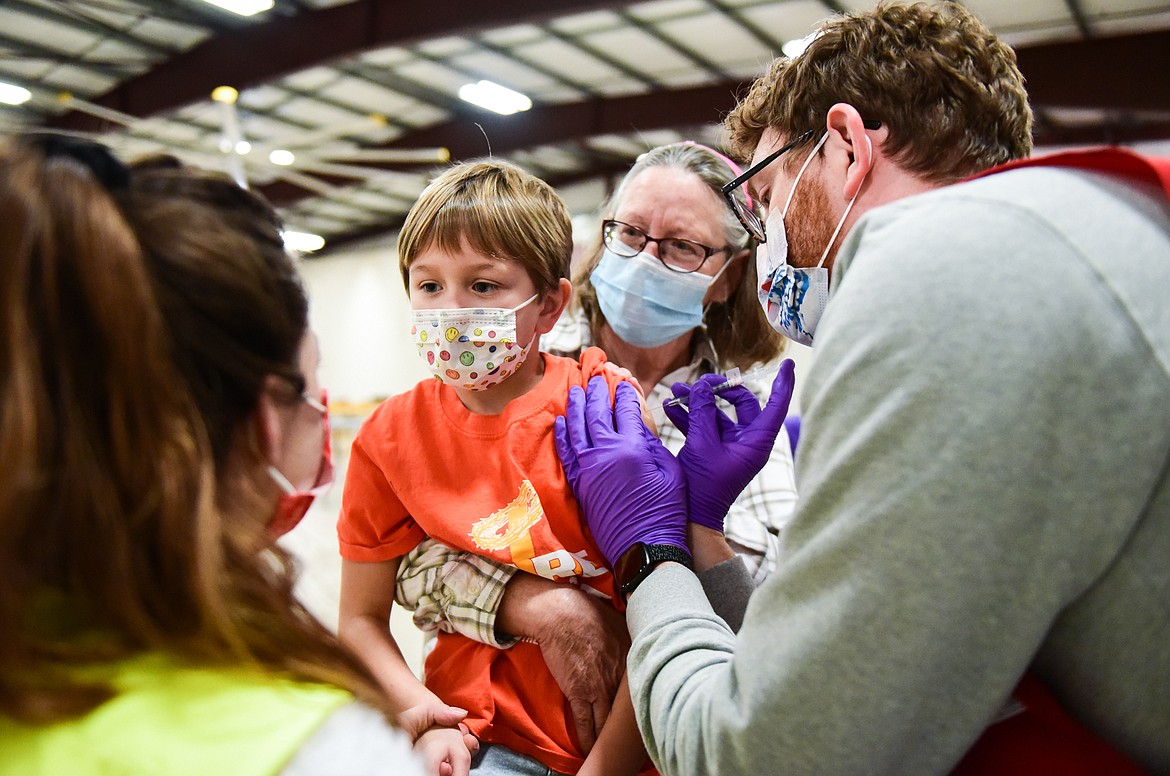 Ember Reed, 6, is administered a Pfizer Covid-19 vaccine with her grandmother and guardian Aggie (back) during a clinic for children ages 5-11 at the Flathead County Fairgrounds in Kalispell on Wednesday, Dec. 1. (Casey Kreider/Daily Inter Lake)