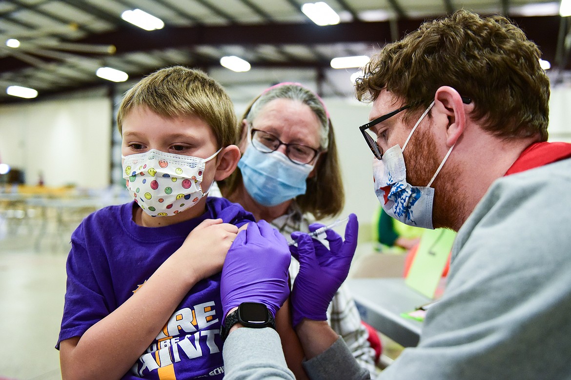 Jay Fuller, 9, is administered a Pfizer Covid-19 vaccine with his grandmother and guardian Aggie (back) during a clinic for children ages 5-11 at the Flathead County Fairgrounds in Kalispell on Wednesday, Dec. 1. (Casey Kreider/Daily Inter Lake)