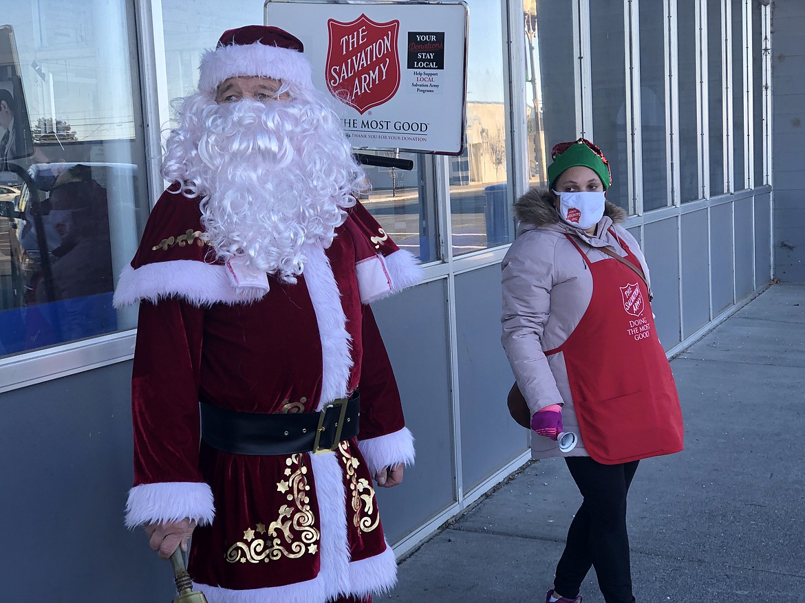 Salvation Army bell ringers Ed MacDonald (left) and Liliana Godinez (right) stand outside the Moses Lake Post Office in December 2020.