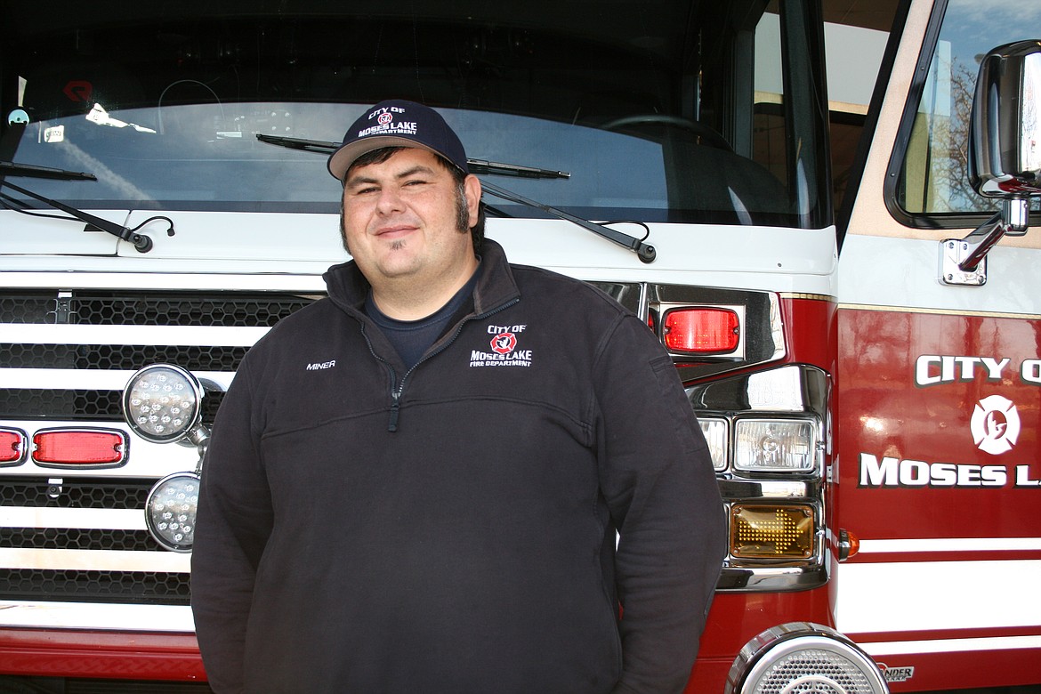 Moses Lake firefighter Mike Miner, founder of the Firefighters for Kids Foundation, stands in front of a fire truck.