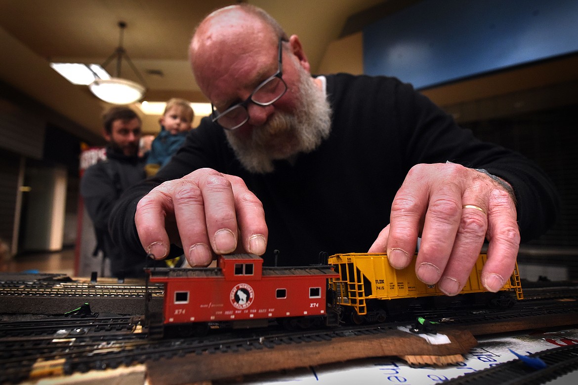 Flathead HO RR Module Group member Dennis Gray places his train cars on the track during the group's demonstration at the Kalispell Center Mall Saturday, November 27. (Jeremy Weber/Daily Inter Lake)