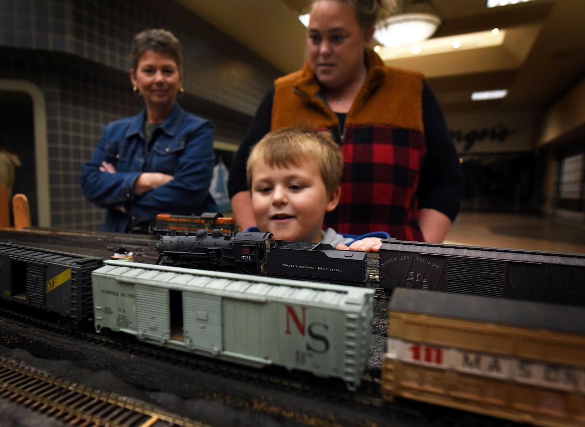 Young Jaxon Hartley, his mother Kayla Hartley and Barb Ruby enjoy the model railroad display at the Kalispell Center Mall Saturday, November 27. (Jeremy Weber/Daily Inter Lake)