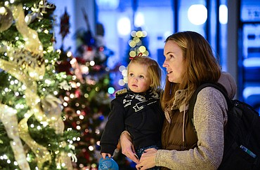 Kate Trieselmann and her daughter Reagan walk through the Festival of Trees at the former Alpine Lighting building at 333 S. Main St. in Kalispell on Friday, Dec. 3. The Festival involves a silent auction where visitors can bid on Christmas trees decorated by local businesses and community members. Proceeds from the auction benefit the Nate Chute Foundation. (Casey Kreider/Daily Inter Lake)