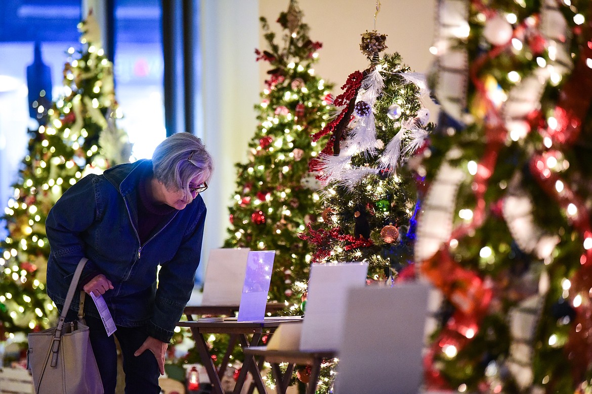 A visitor looks over a bidding sheet at the Festival of Trees at the former Alpine Lighting building at 333 S. Main St. in Kalispell on Friday, Dec. 3. The Festival involves a silent auction where visitors can bid on Christmas trees decorated by local businesses and community members. Proceeds from the auction benefit the Nate Chute Foundation. (Casey Kreider/Daily Inter Lake)