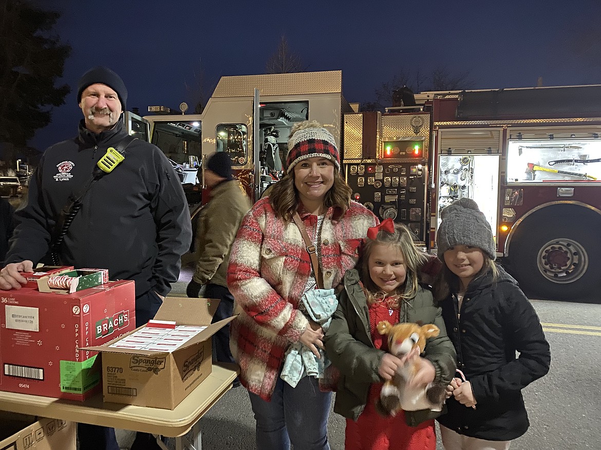 From left: firefighter Brett Lynch, Hayden resident Julie Moak, Addy Moak, 7 and Shaeleigh McDermott, 8. Kootenai County Fire and Rescue was on hand at Friday night's Winterfest to hand out candy canes and share the magic of the firetrucks with eager children.