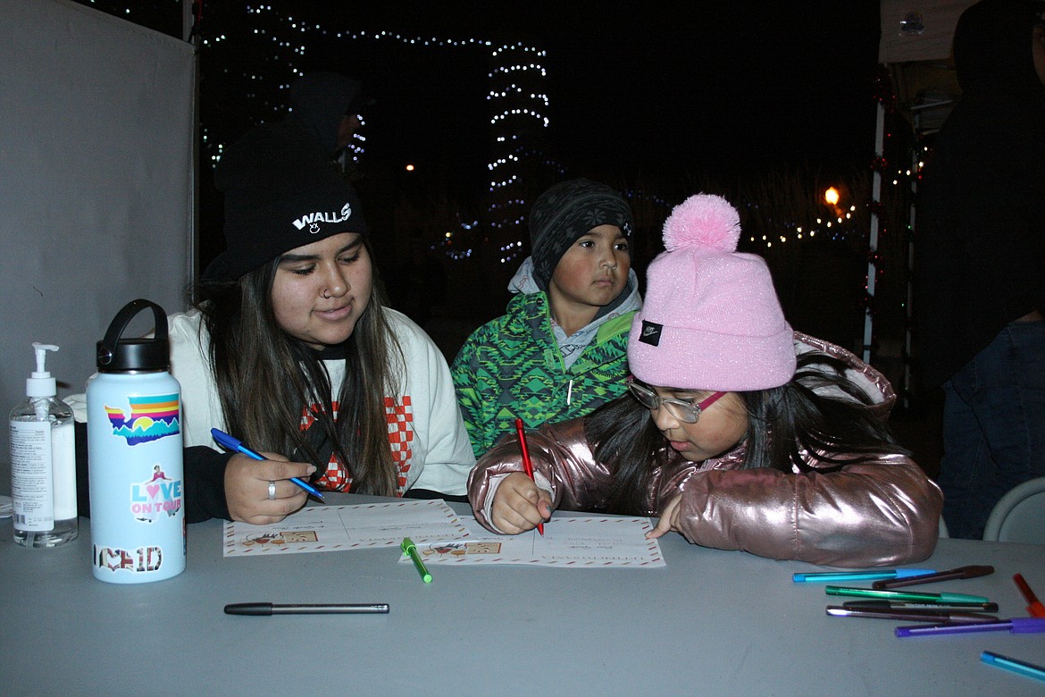 Isela Garcia, left, and Naleyah Montoya, right, work on letters to Santa during the street party prior to the 26th annual Agricultural Parade Friday in Moses Lake.