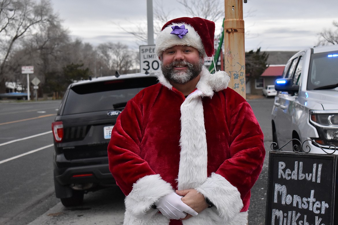 Soap Lake Police Department Officer Justin Rowland, is dressed in a Santa costume for the Tip-a-Cop event Monday. He’s been doing singing-grams to raise money for the Soap Lake Police Benevolent Fund for four out of the last five years due to COVID-19 restrictions last year.