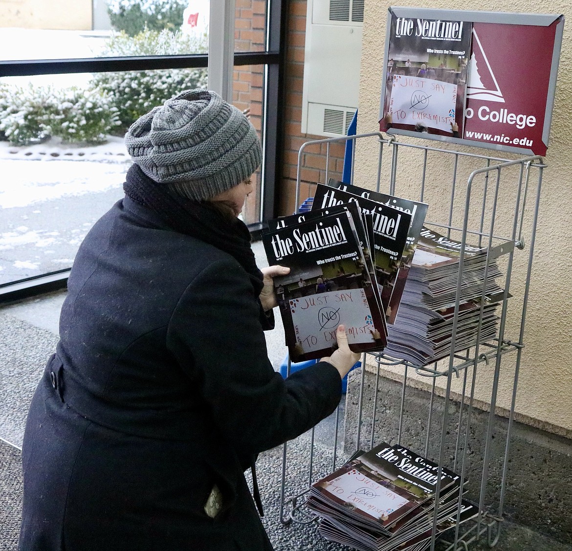 North Idaho College Student Dana Parsons, magazine editor for The Sentinel, NIC's student news organization, puts out copies of The Sentinel's latest magazine issue on a rack at the Student Union Building at NIC's main campus in Coeur d'Alene on Monday. HANNAH NEFF/Press