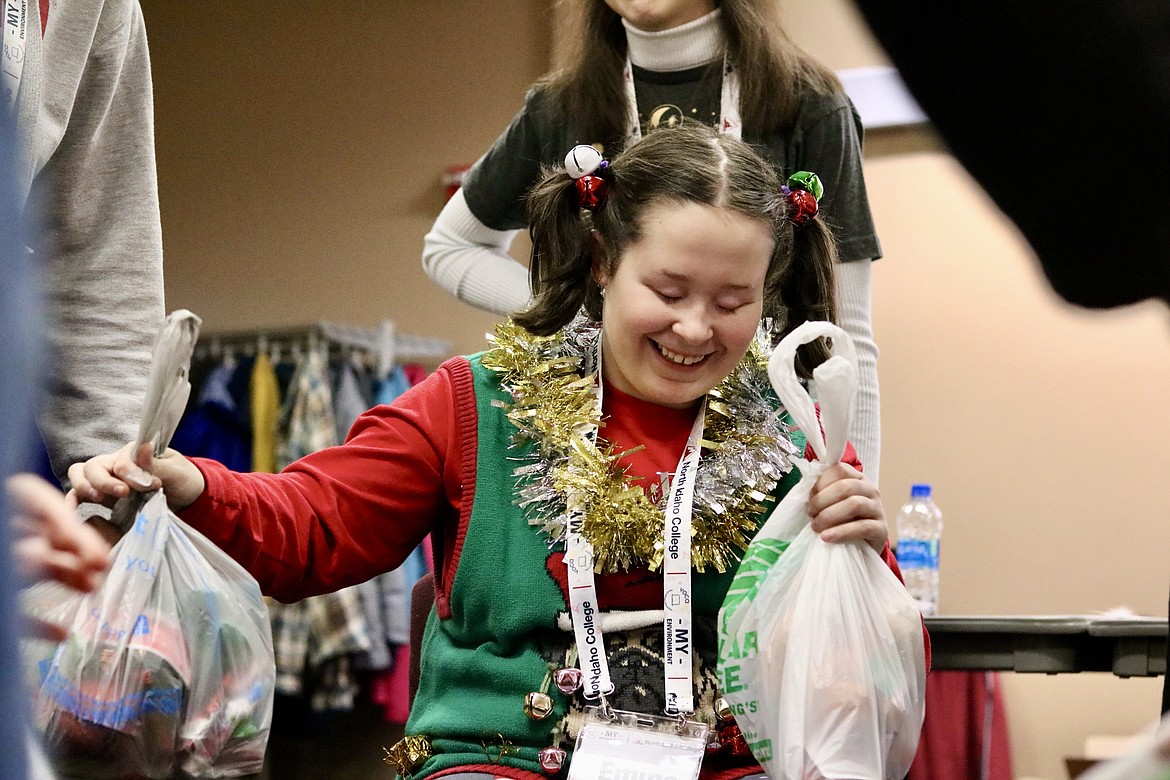 Fifteen-year-old Emma Erckenbrack smiles as she plays along during a gift exchange game at the Christmas get together for visually impaired students at North Idaho College on Saturday. HANNAH NEFF/Press