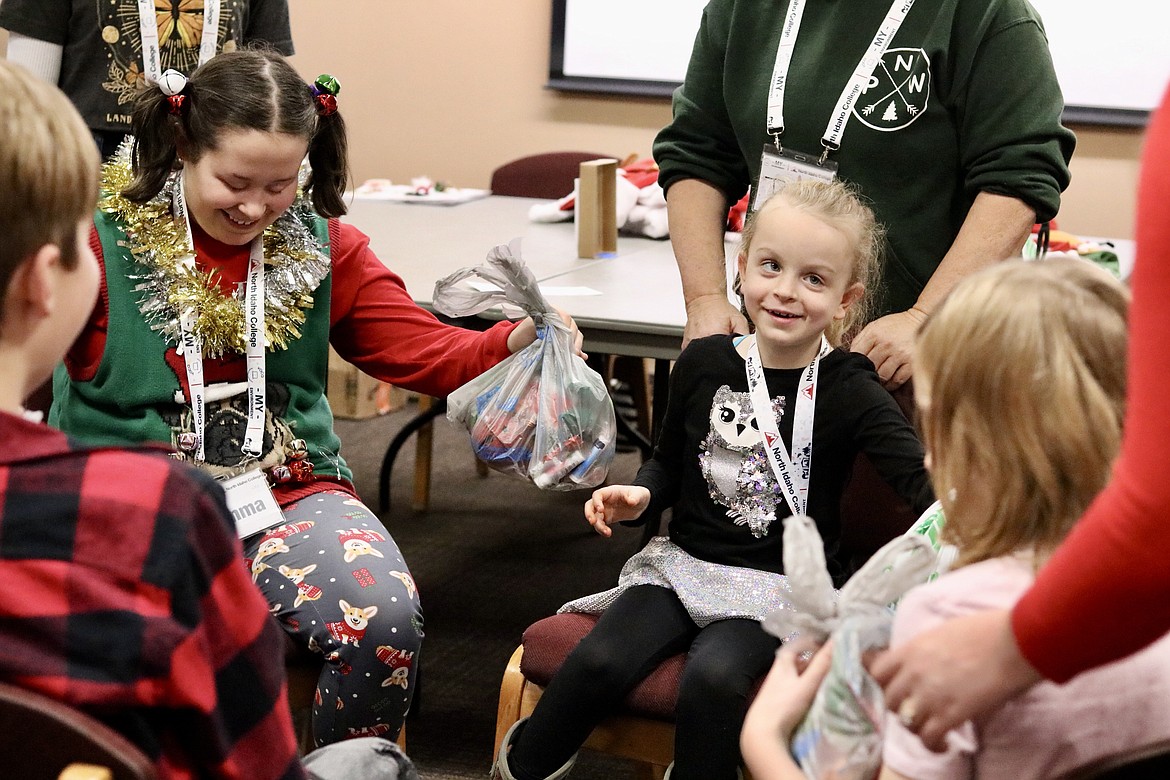 From left, Emma Erckenbrack, 15, and Aubriella Gibson, 6, show their smiles during a gift exchange game at a Christmas gathering for visually impaired students at North Idaho College on Saturday. HANNAH NEFF/Press