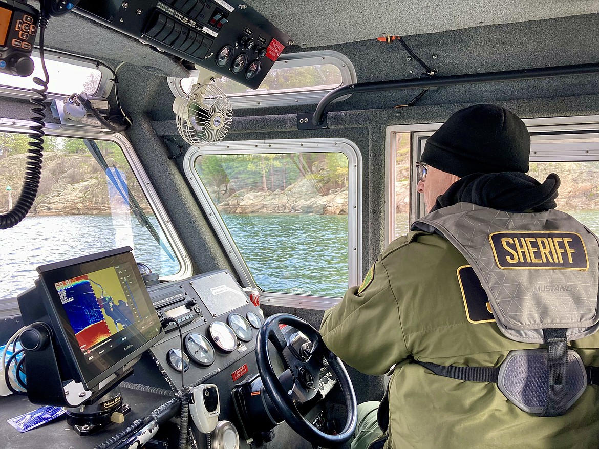 KCSO Deputy Gerald Wallace drives a boat to keep an eye on the KCSO dive team as they extract trash from the bottom of Lake Coeur d'Alene Wednesday. HANNAH NEFF/Press