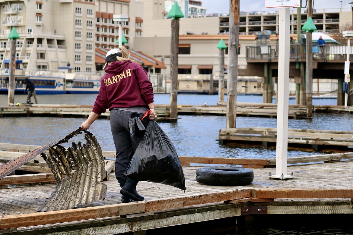 Volunteer Dawn Hannah of Priest River carries trash off the dock during the underwater cleanup of Lake Coeur d'Alene near Tubbs Hill and the Third Street boat launch. HANNAH NEFF/Press