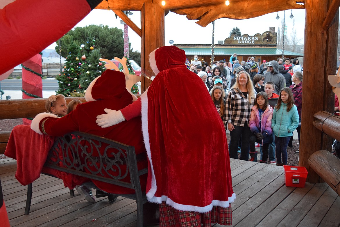 Santa and Mrs. Claus, who are close friends of Glenn and Joey Owens of Marysville, Washington, meet with kids during the Soap Lake Winterfest celebration Saturday.