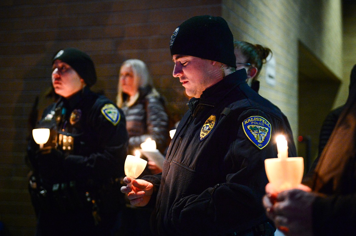 Kalispell police officers Brady Gray, left, and John Fusaro hold candles during the annual Blue Light Tree Lighting Ceremony to honor fallen law enforcement officers outside the Flathead County Justice Center in Kalispell on Thursday, Dec. 9. (Casey Kreider/Daily Inter Lake)