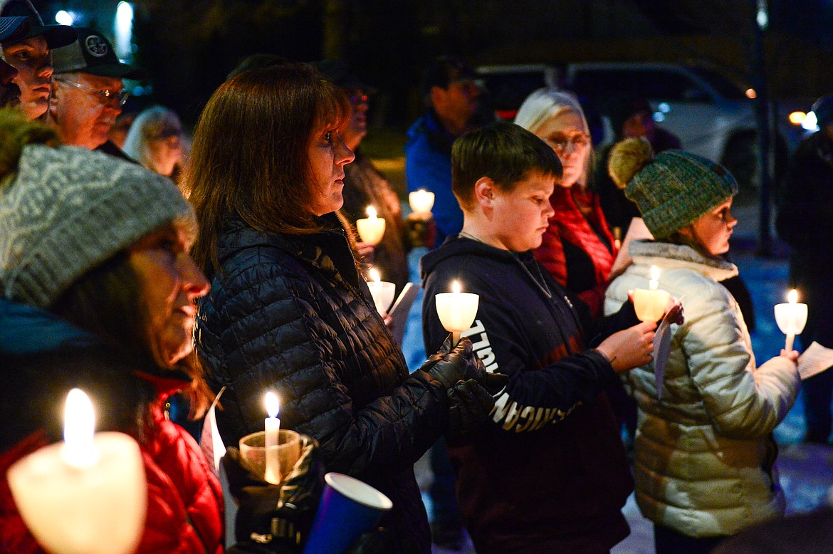 Attendees hold candles during the annual Blue Light Tree Lighting Ceremony to honor fallen law enforcement officers outside the Flathead County Justice Center in Kalispell on Thursday, Dec. 9. (Casey Kreider/Daily Inter Lake)