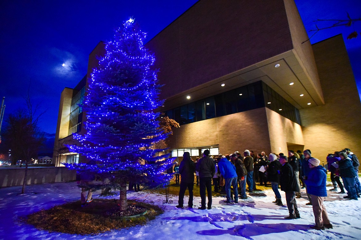 Attendees gather to hold candles and sing "Silent Night" and "Let There Be Peace on Earth" during the annual Blue Light Tree Lighting Ceremony to honor fallen law enforcement officers outside the Flathead County Justice Center in Kalispell on Thursday, Dec. 9. (Casey Kreider/Daily Inter Lake)