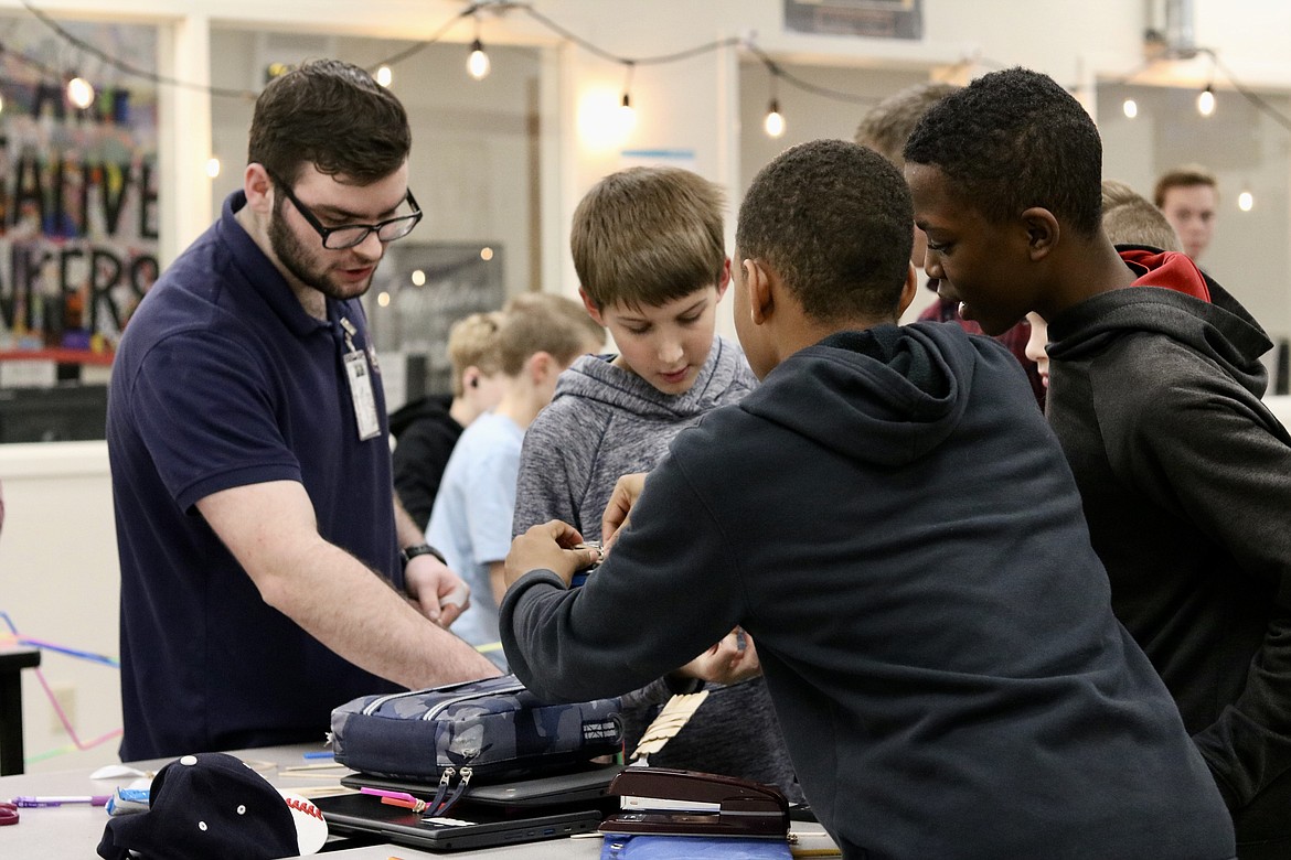 On left, Coeur d'Alene Charter Academy senior Ryan Eaton, creator of the STEM and Engineering Club started in fall at Canfield Middle School, checks in with a group of middle schoolers during the club meeting on Dec. 1. HANNAH NEFF/Press