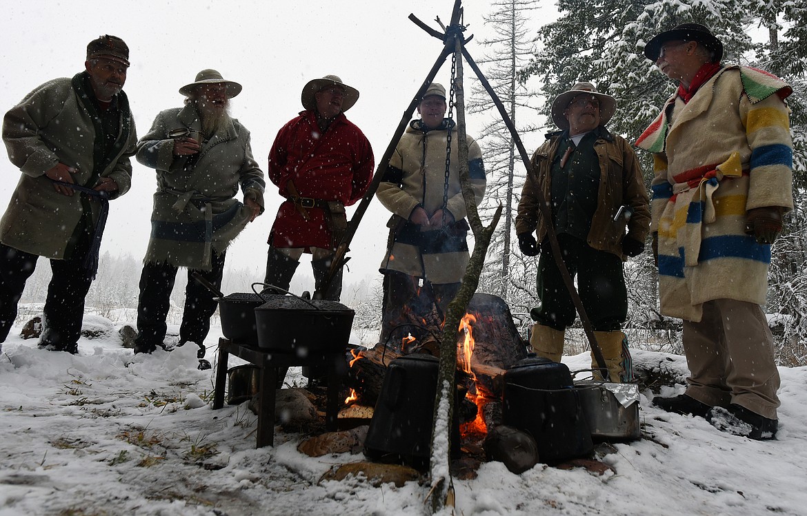 Flathead Muzzleloaders Association members Mike Jorgensen, Dave Swanson, Darryl Askvig, Sean McQueen, Jon Erdman and Randy Burns trade stories around the campfire at the a gathering of the group near Columbia Falls Saturday. Dec. 4. (Jeremy Weber/Daily Inter Lake)