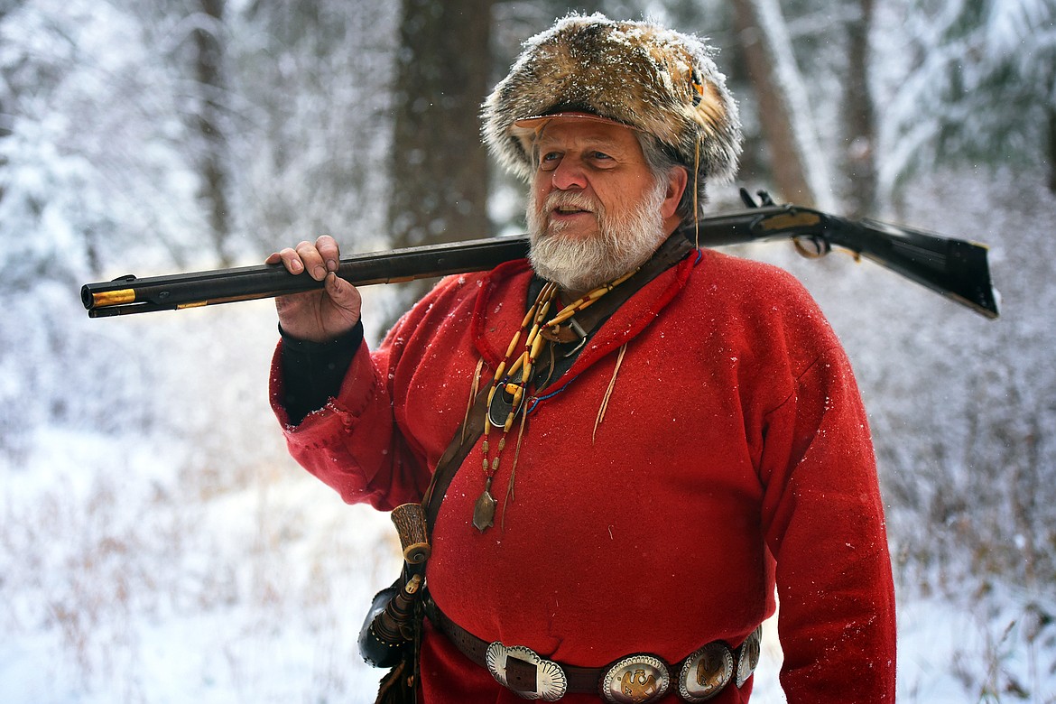 Flathead Muzzleloaders Association member Gene Gordner dons his badger-skin hat and flintlock rifle as he makes his way between shooting stations Saturday, Dec. 4. (Jeremy Weber/Daily Inter Lake)