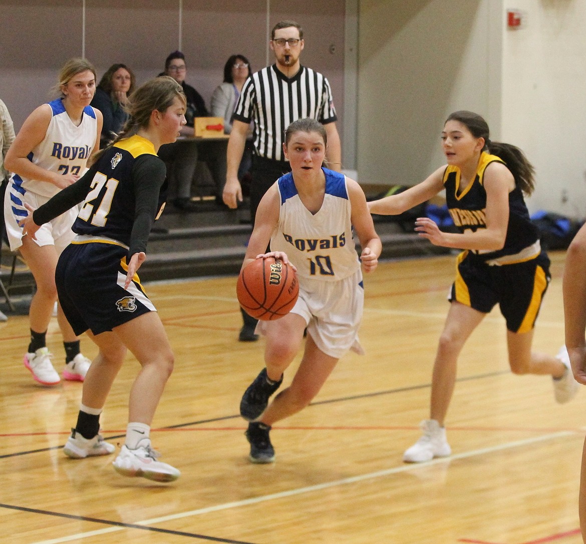 MARK NELKE/Press
Danica Kelly (10) of North Idaho Christian drives between Katie Yount, left, of Genesis Prep and Summer Nelke of Genesis Prep on Friday at Holy Family Catholic School in Coeur d'Alene.