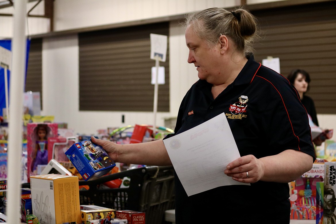 Opal Spatz, a Marine Corps League member, sorts through toy donations for Toys for Tots at the Kootenai County Fairgrounds on Friday. HANNAH NEFF/Press