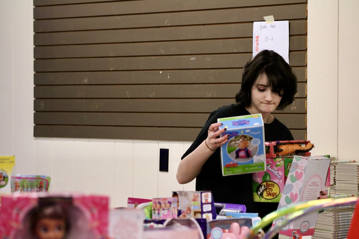 Volunteer Kylie Boyle helps sort through toys for the Toys for Tots campaign at the Kootenai County Fairgrounds on Friday. HANNAH NEFF/Press
