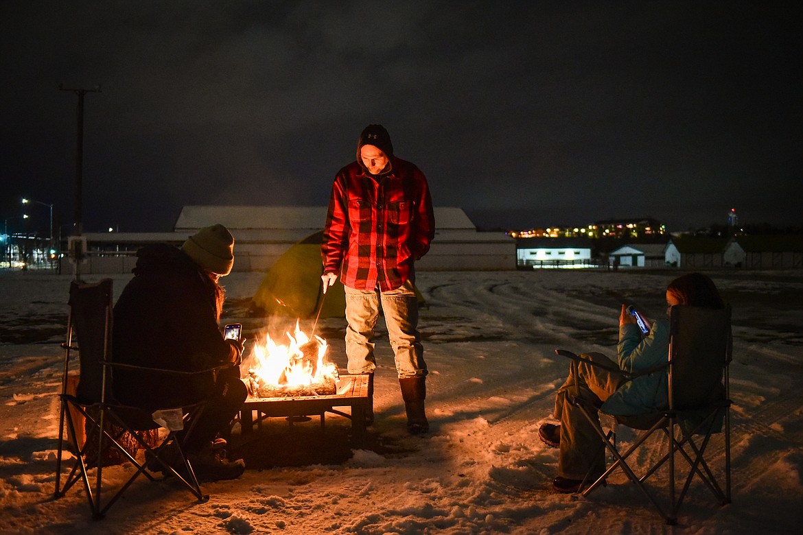 Brandy Hinzman, Trevor Kjensrud and Harper Hinzman sit by a fire during When the Night Comes, a fundraiser held by the nonprofit Sparrow's Nest of Northwest Montana which benefits homeless high school students in the Flathead Valley on Friday, Dec. 10. Participants spent the night outdoors sleeping in cars and tents at the Flathead County Fairgrounds. Sparrow's Nest received over $42,000 in donations according to executive director Rachelle Morehead. (Casey Kreider/Daily Inter Lake)