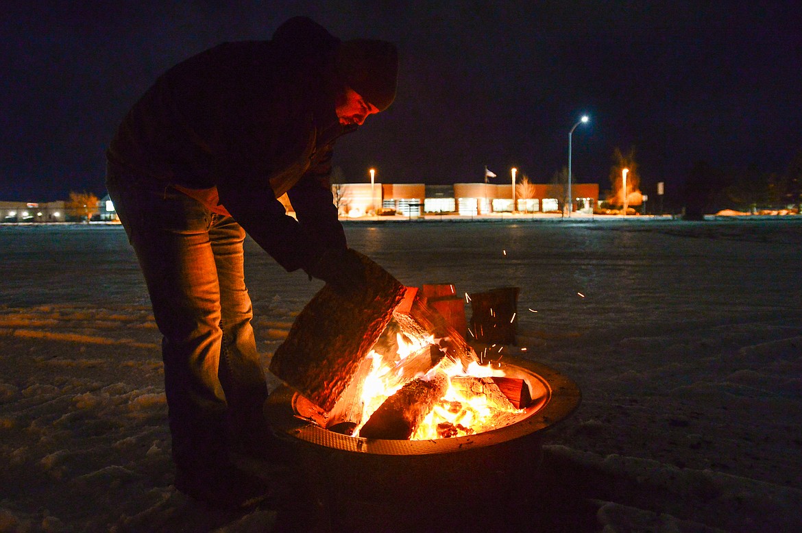Blake Robinson adds a log to a fire during When the Night Comes, a fundraiser held by the nonprofit Sparrow's Nest of Northwest Montana which benefits homeless high school students in the Flathead Valley on Friday, Dec. 10. Participants spent the night outdoors sleeping in cars and tents at the Flathead County Fairgrounds. Sparrow's Nest received over $42,000 in donations according to executive director Rachelle Morehead. (Casey Kreider/Daily Inter Lake)