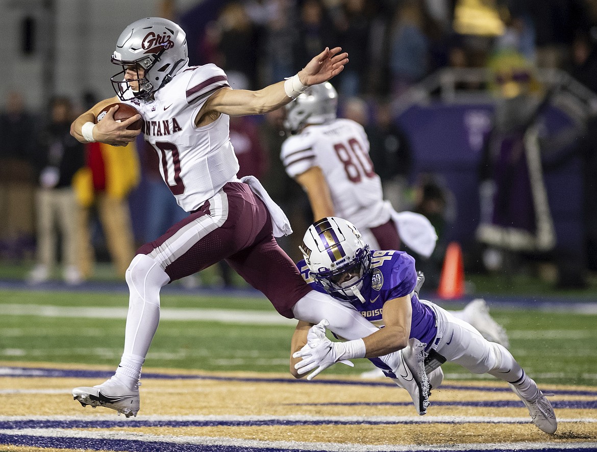 Montana quarterback Robbie Patterson (10) gets wrapped up by James Madison safety Francis Meehan (49) during the second half of an NCAA FCS football playoff game in Harrisonburg, Va., Friday, Dec. 10, 2021. (Daniel Lin/Daily News-Record via AP)