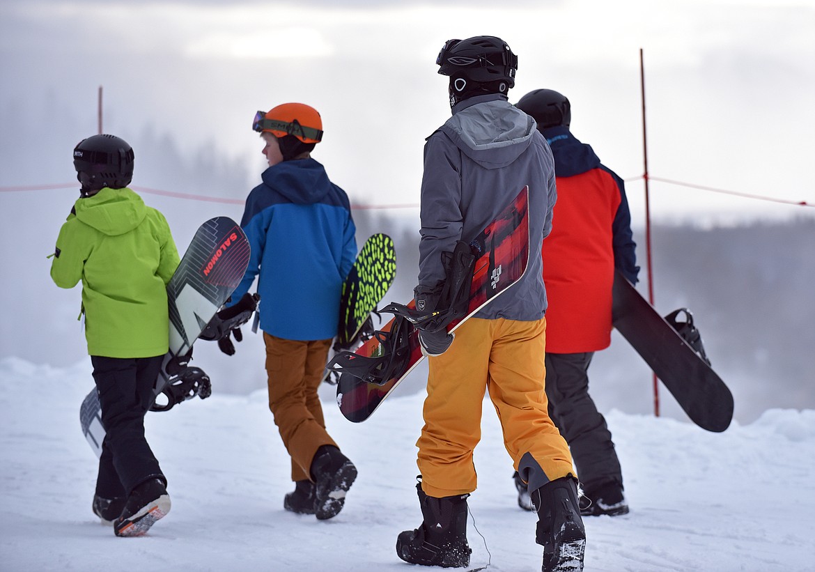 Young snowboarders on their way to get in line at Whitefish Mountain Resort's opening day of the 2021-22 season Thursday, Dec. 9. (Whitney England/Whitefish Pilot)