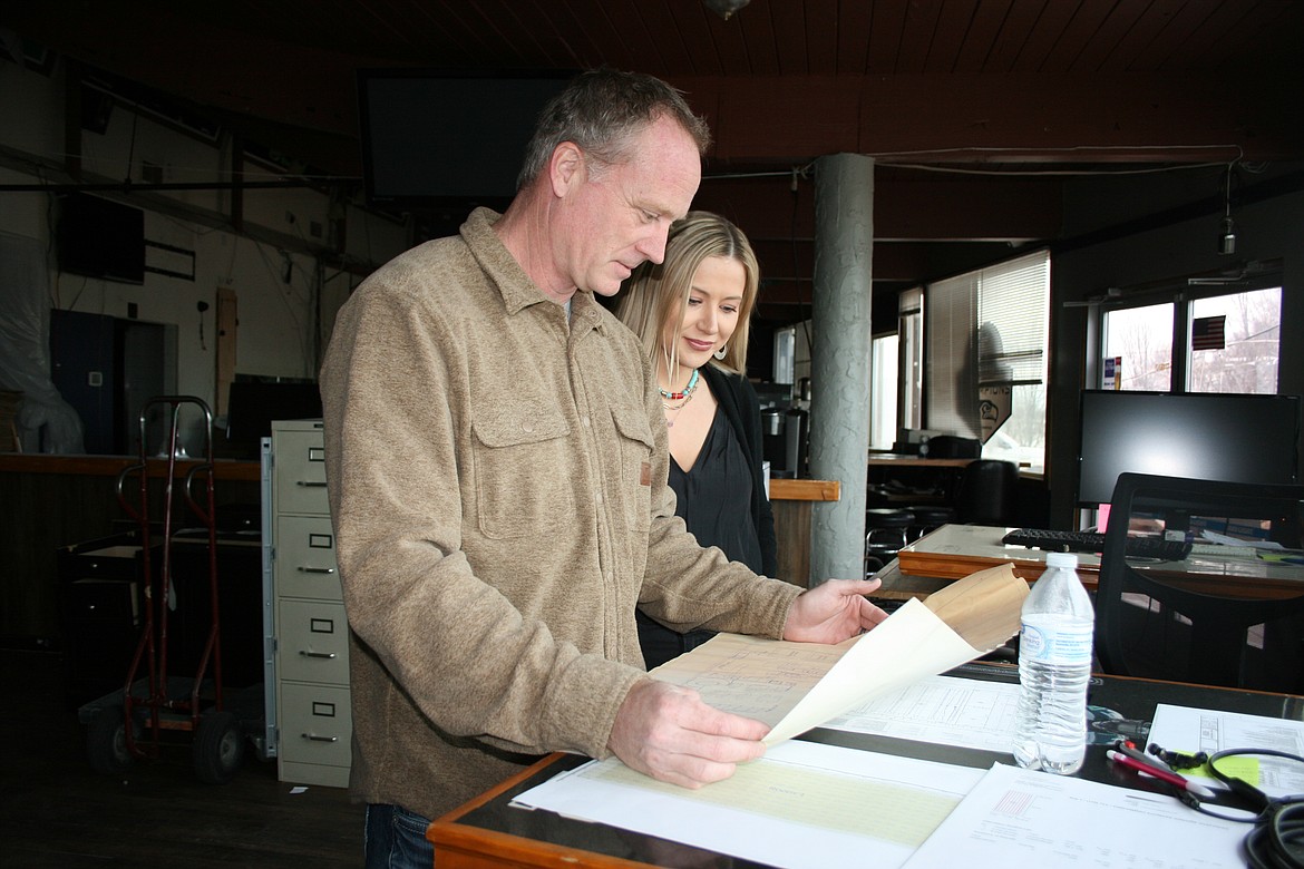 Rob (left) and Anna Van Diest study original plans for the Broadway Bar & Grill. The Van Diests bought the building and are remodeling it into office space, as well as a bar and restaurant.