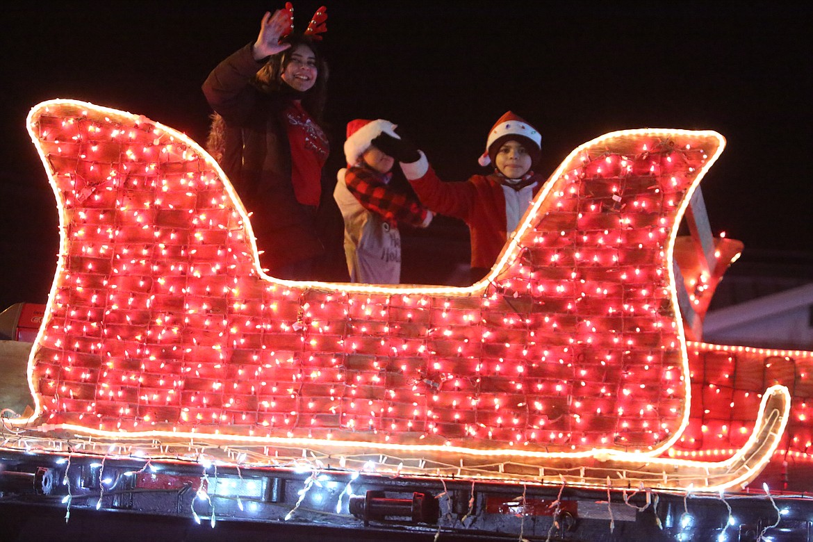 Riders wave to the spectators during Friday’s Christmas in the Park parade in Mattawa.