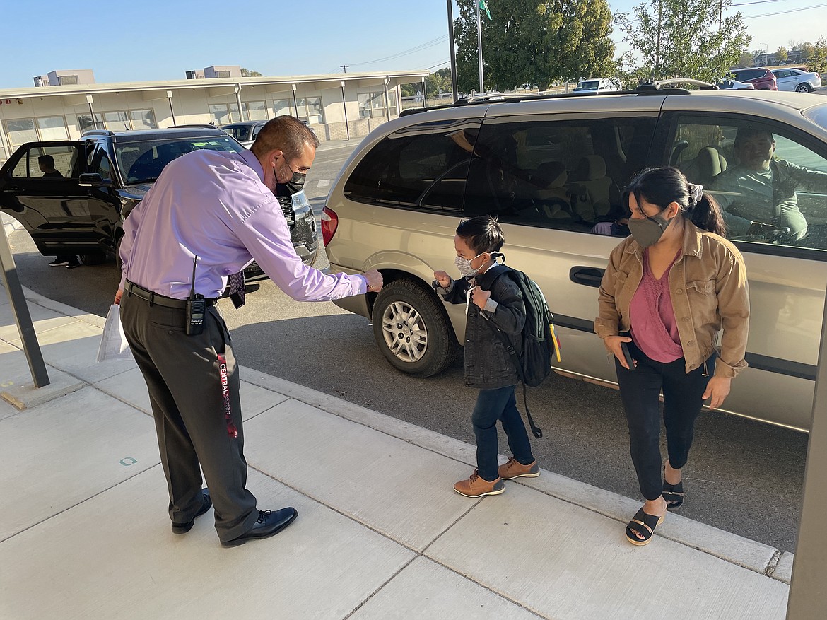 George Elementary School Principal Manuel Ramos Jr. gives a fist-bump to first-grader Aaron Guzman as he arrives for the first day of school.