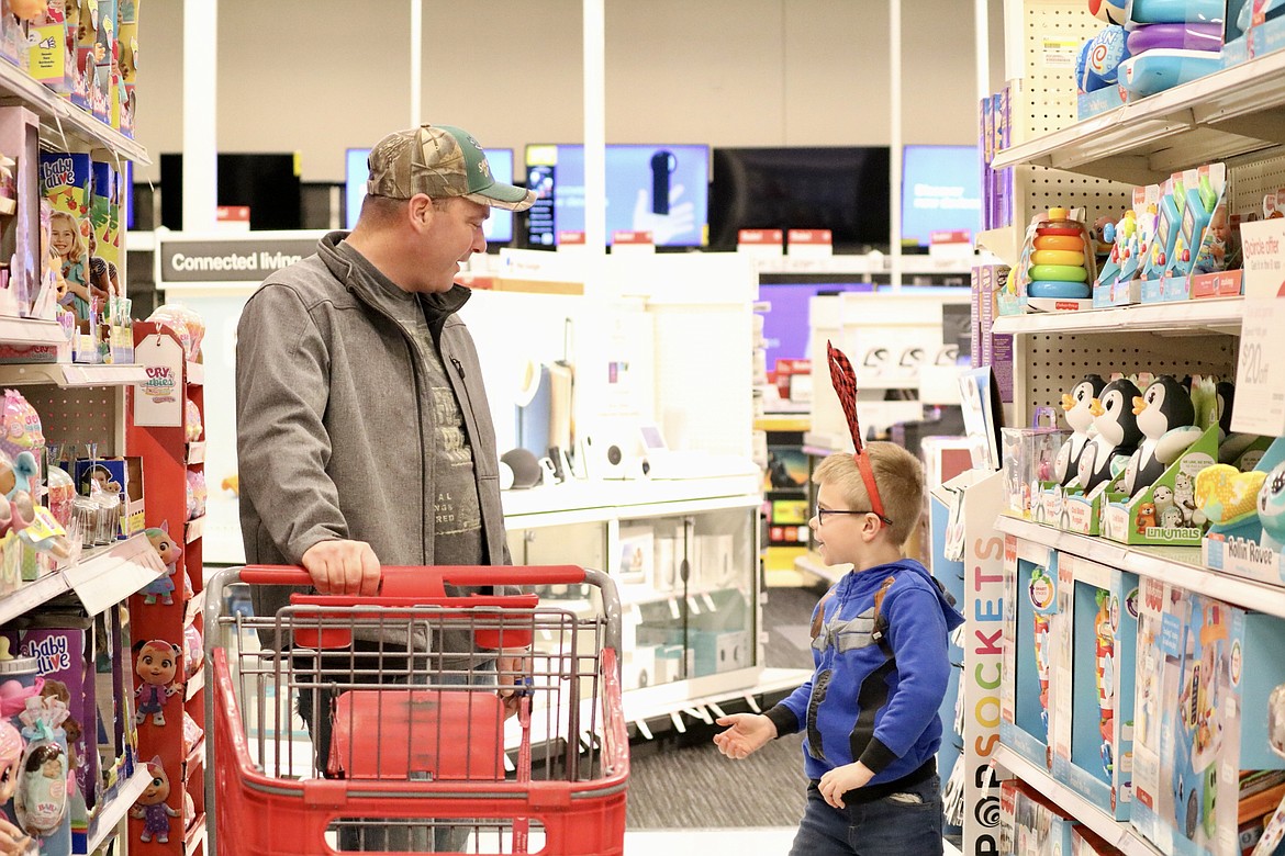 Six-year-old Keith chats with his shopping buddy Sergeant First Class Nick Blankenship as the two made their way around Target on Tuesday morning, selecting gifts for Keith's family members. HANNAH NEFF/Press