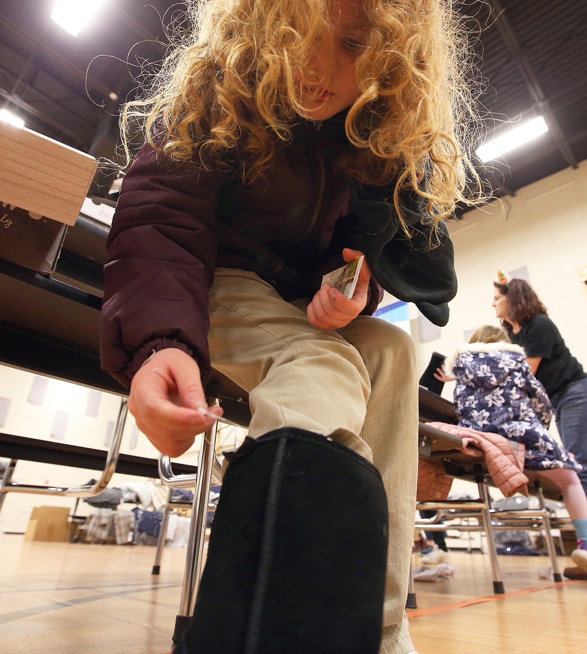 Adalynn MacArthur tries on new Bearpaw boots Tuesday at the Lola & Duane Hagadone Boys & Girls Club.